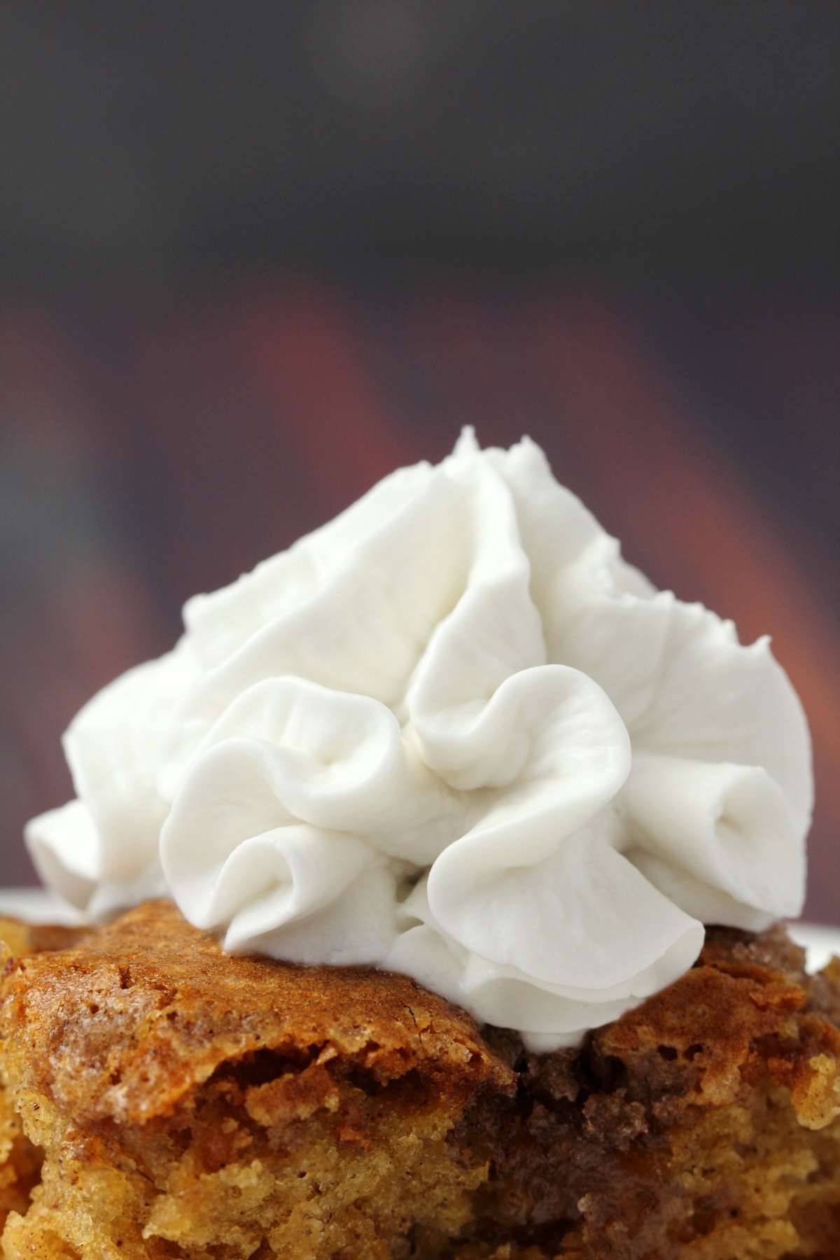 Vegan whipped cream on top of a slice of apple cake. 