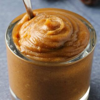 Date caramel in a glass jar with a spoon.