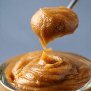 Date caramel in a glass jar with a spoon.