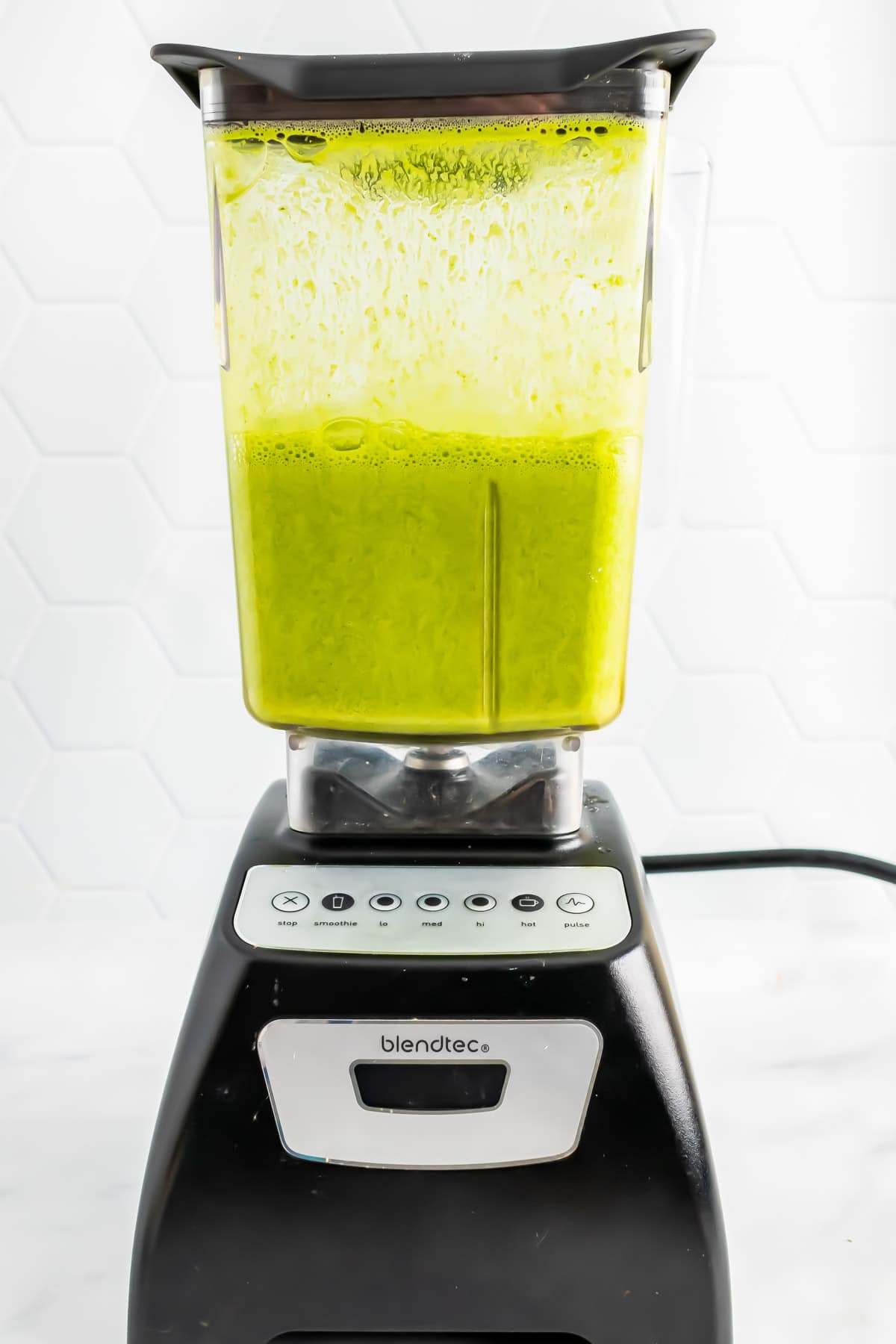 Blended orange juice and spinach in a blender jug.