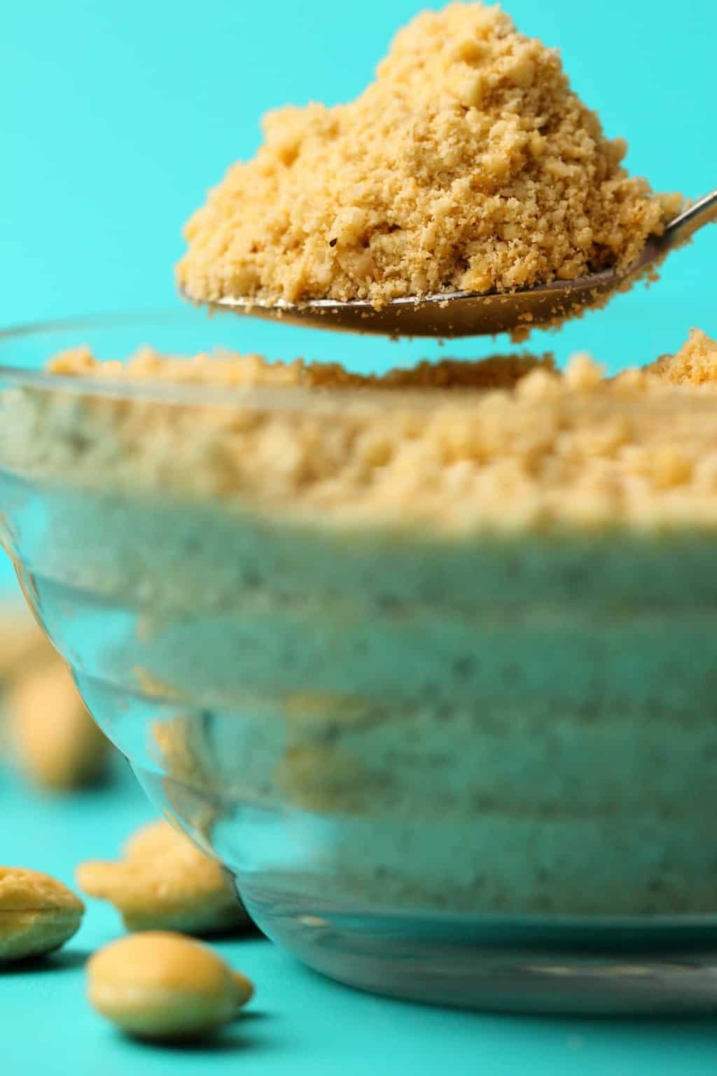 Vegan parmesan cheese in a glass bowl with a spoon. 