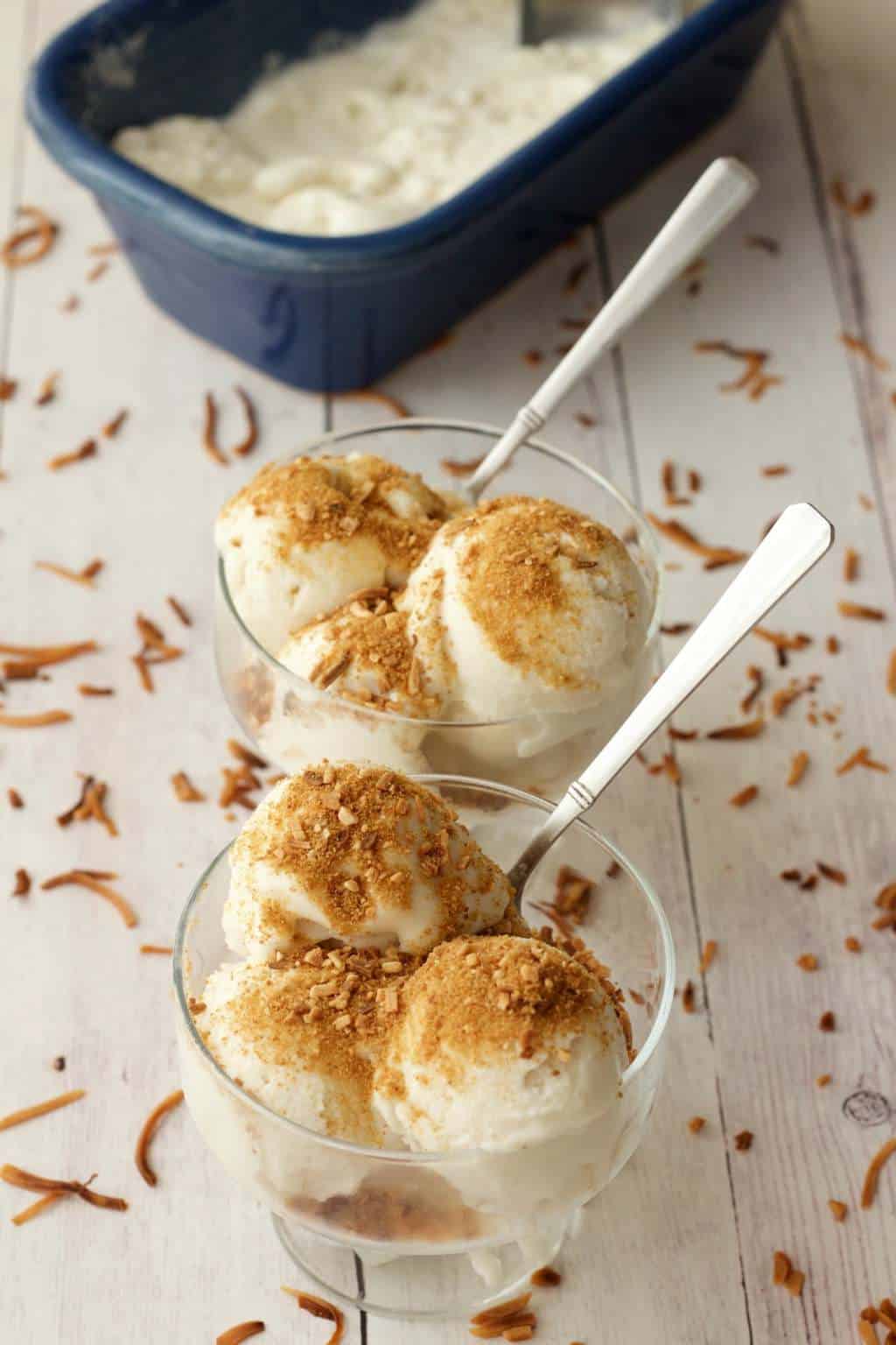 Vegan coconut ice cream topped with toasted coconut in glass dishes. 