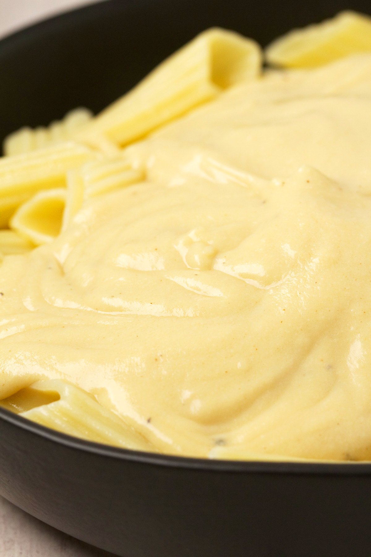 Vegan cheese sauce over a bowl of pasta. 