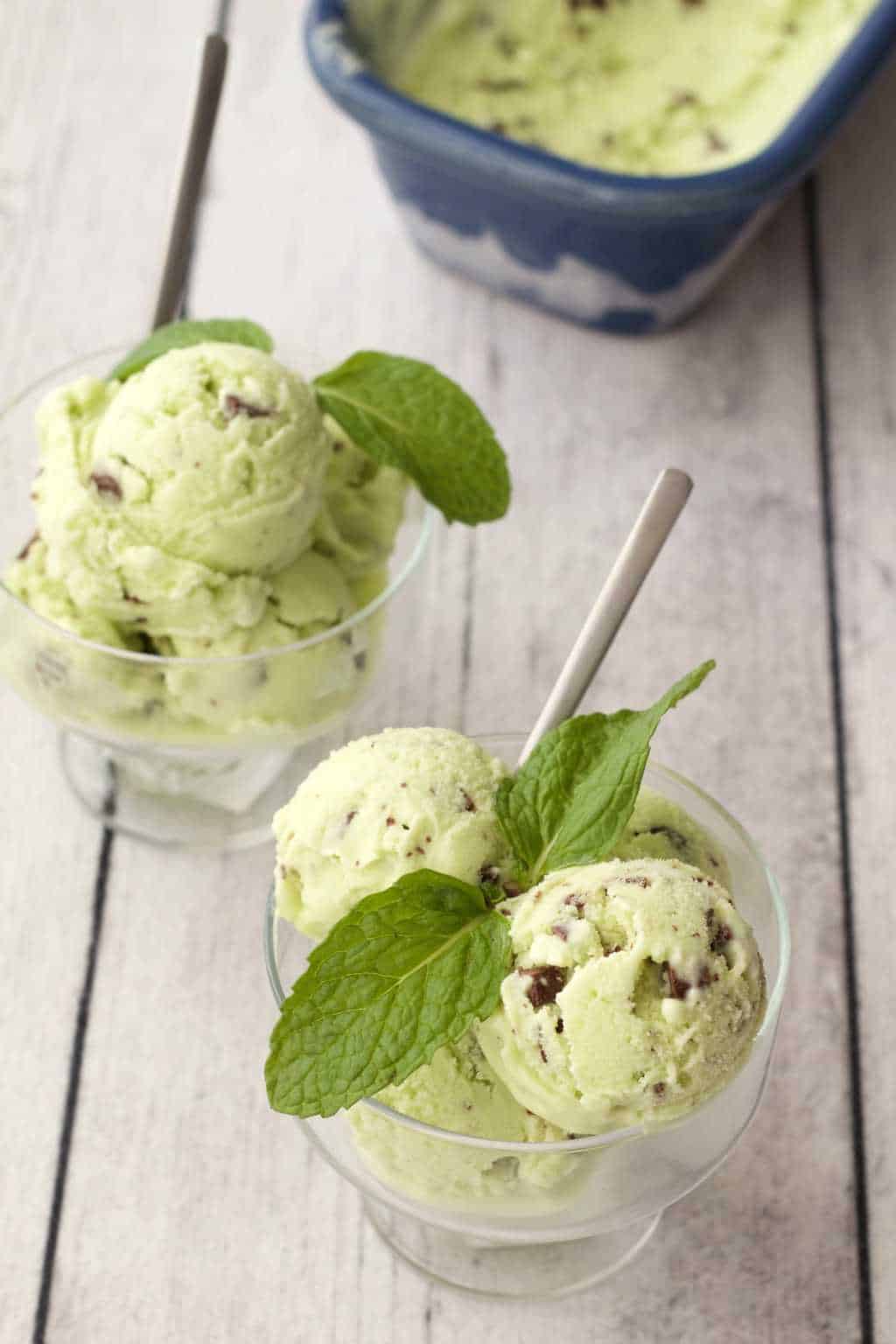 Scoops of vegan mint chocolate chip ice cream in glass bowls. 