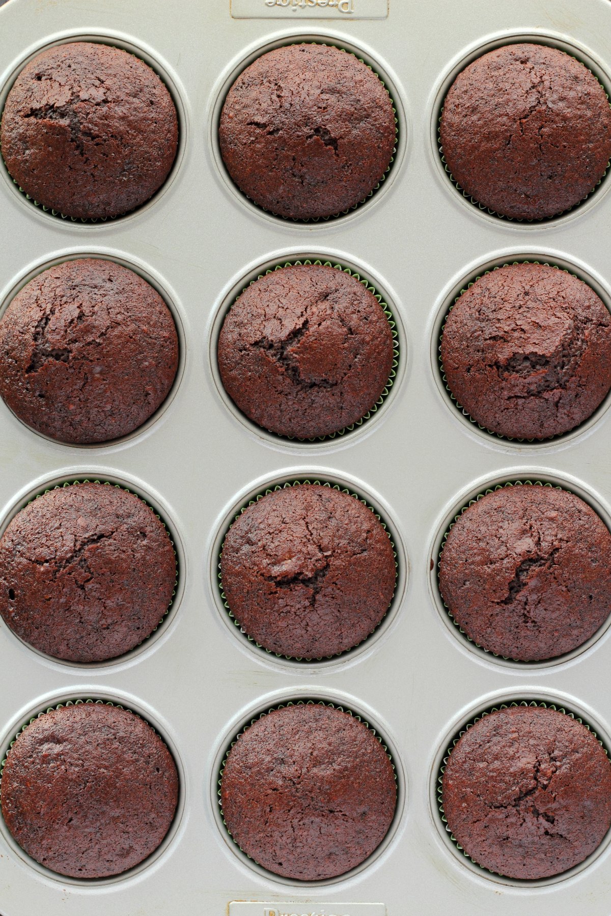 Baked chocolate cupcakes in a cupcake tray.