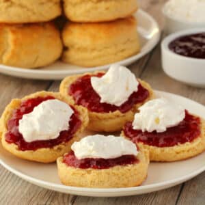 Vegan scones topped with strawberry jam and vegan whipped cream.