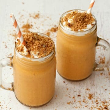 Carrot cake smoothies topped with vegan whipped cream and toasted coconut.