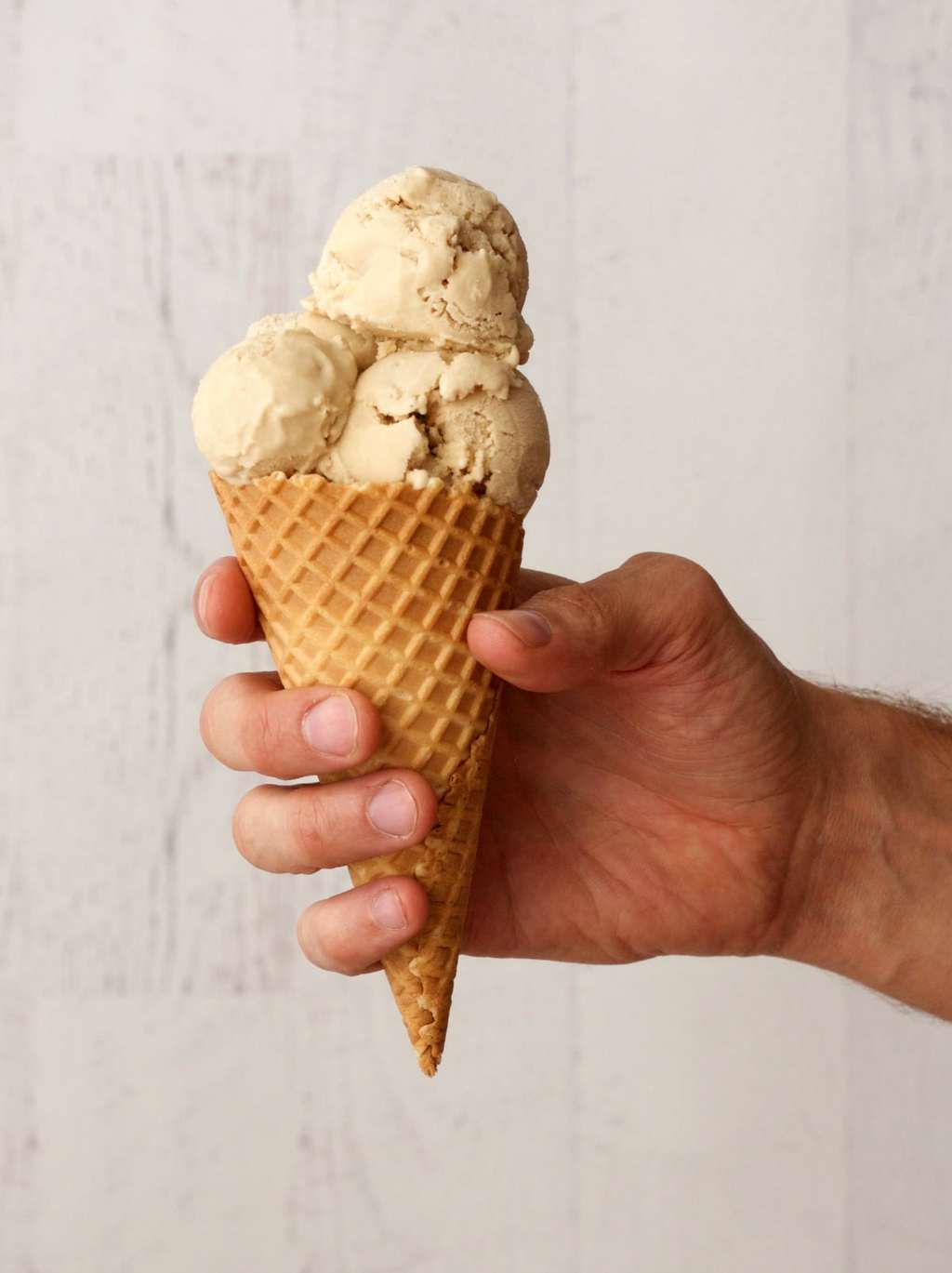 Salted caramel ice cream scoops in an ice cream cone. 