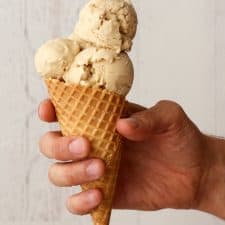 Vegan salted caramel ice cream scoops in a sugar cone.