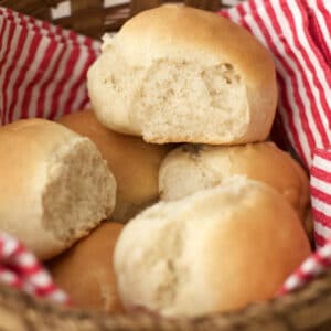 Vegan dinner rolls in a basket with a red and white striped napkin.