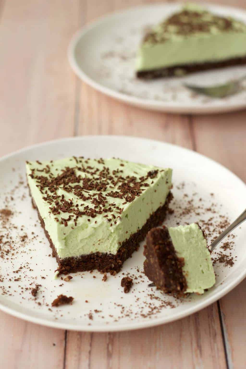 Slice of vegan grasshopper pie on a white plate with a cake fork. 