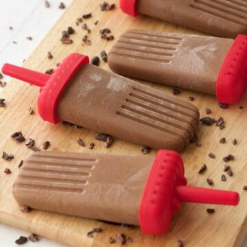 Vegan chocolate popsicles on a wooden board.