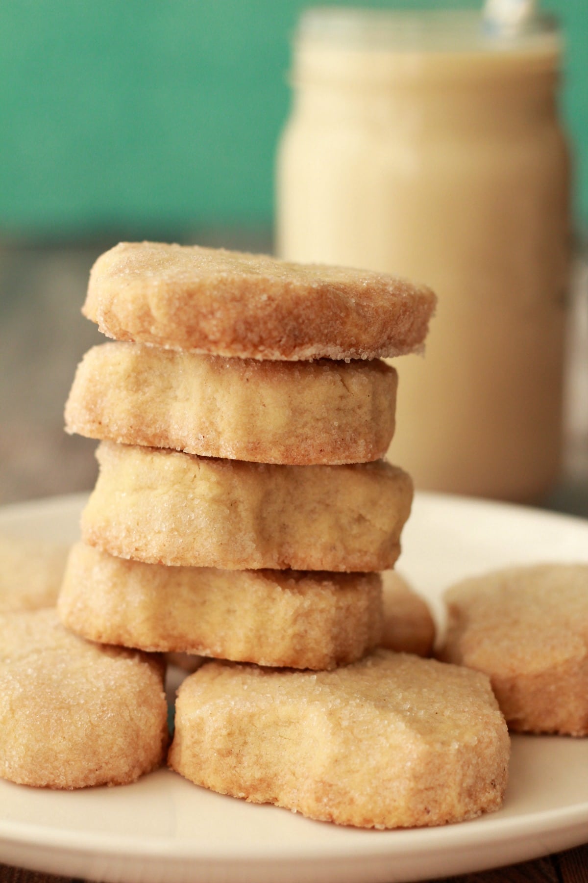 Vegan shortbread cookies stacked up on a white plate. 