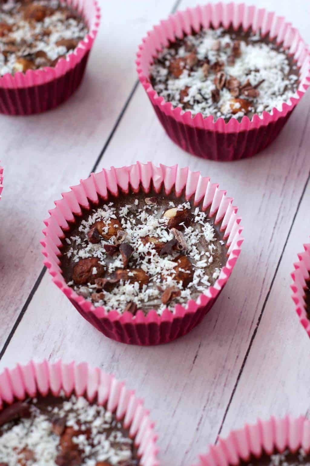 Raw chocolate in cupcake liners topped with shredded coconut and cacao nibs. 