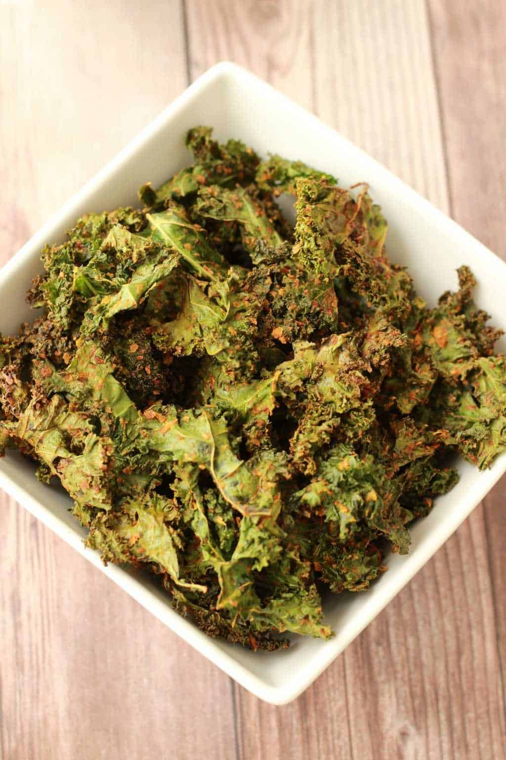 Kale chips in a square bowl. 