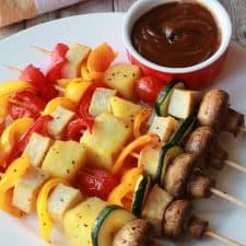 Vegetable skewers on a white plate.