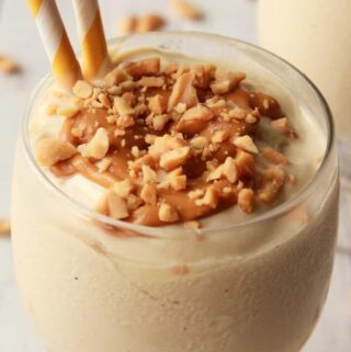 Vegan peanut butter milkshake topped with drizzled peanut butter and crushed peanuts