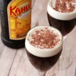 Kahlua coffees in wine glasses with vegan whipped cream and chocolate shavings.