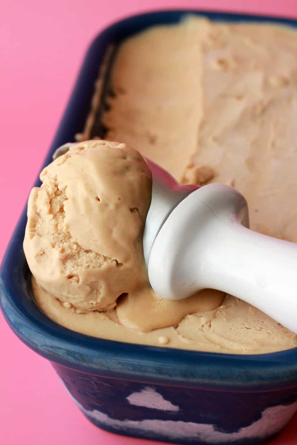Scooping peanut butter ice cream with an ice cream scoop. 