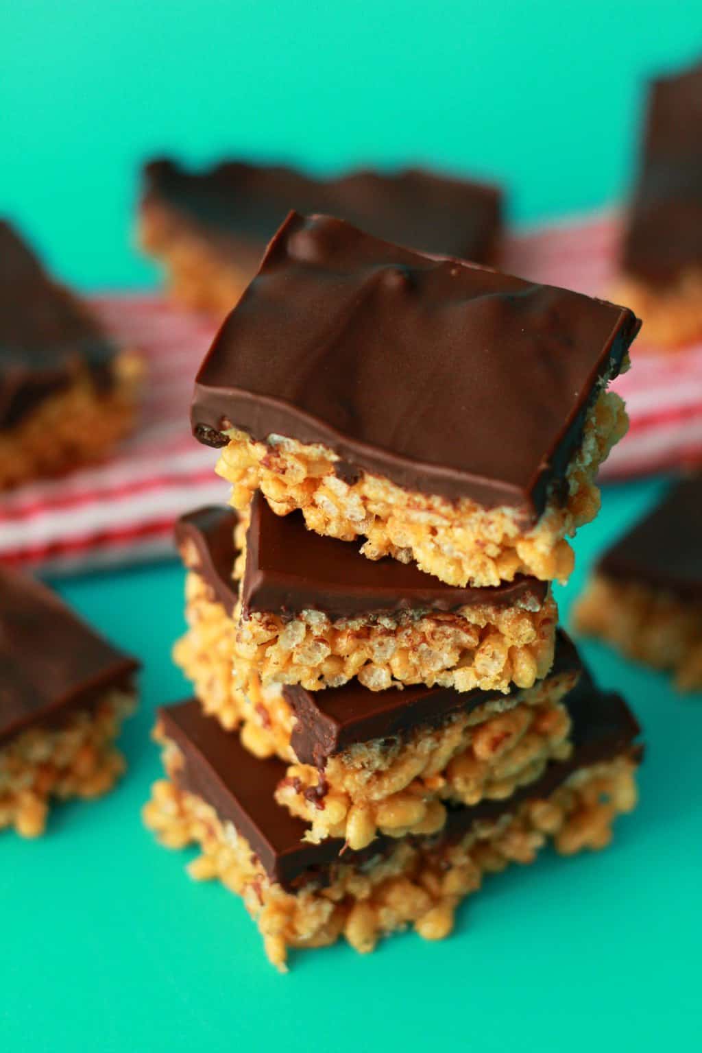 Chocolate topped rice krispie treats in a stack. 