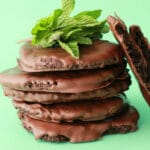 Vegan thin mint cookies in a stack topped with fresh mint.