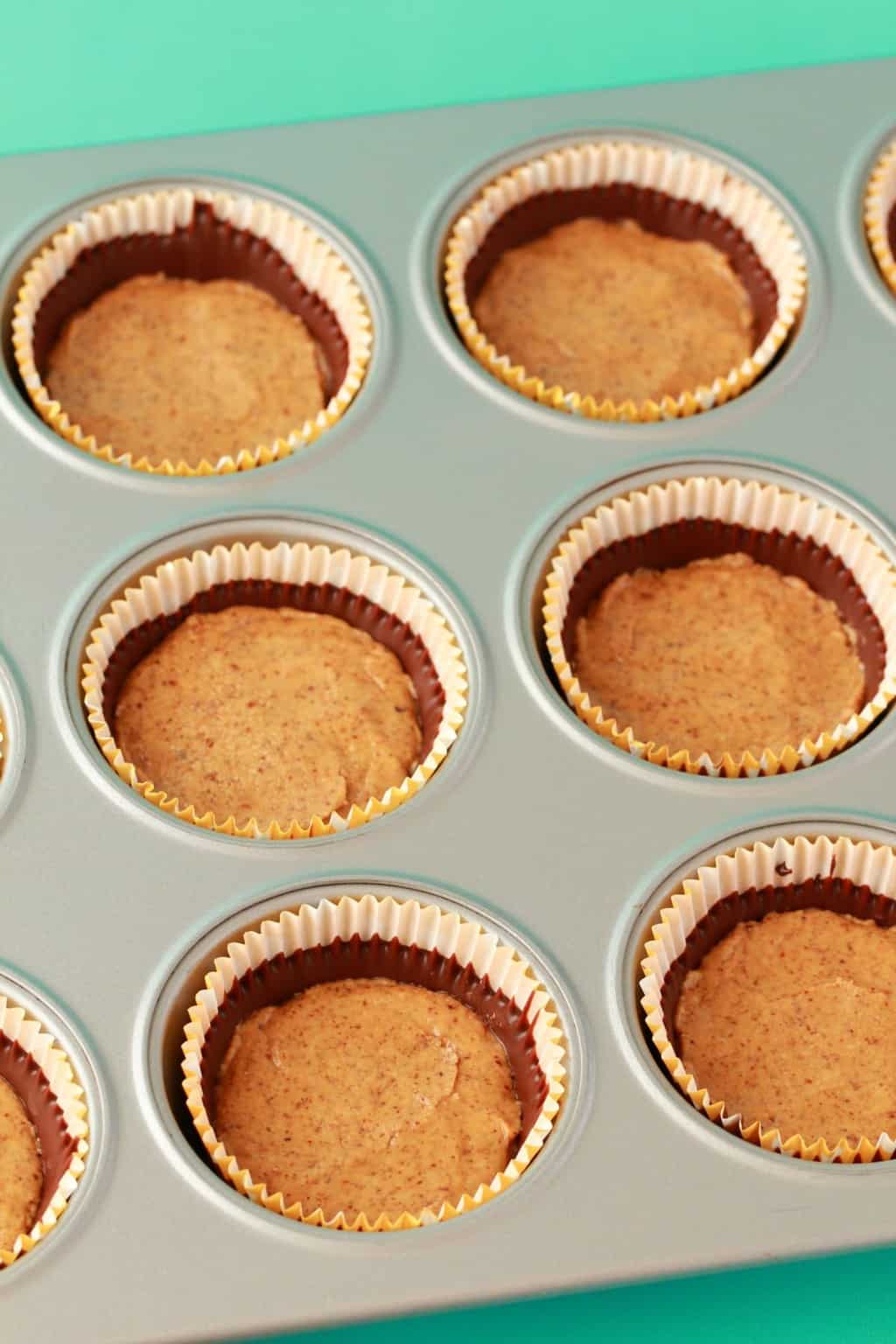 Almond butter filling added to cupcake liners. 