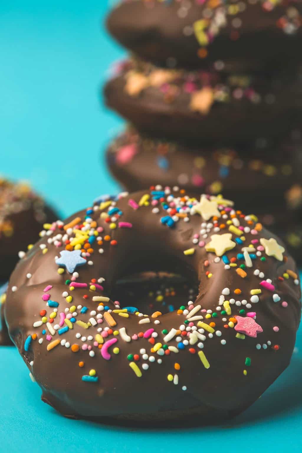 Vegan chocolate donuts topped with chocolate and sprinkles. 