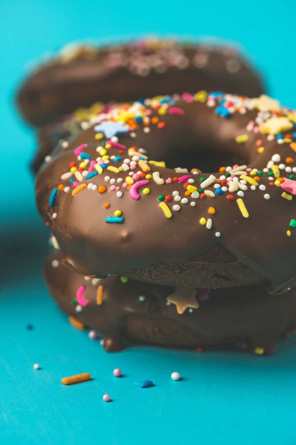 Vegan chocolate donuts topped with sprinkles. 