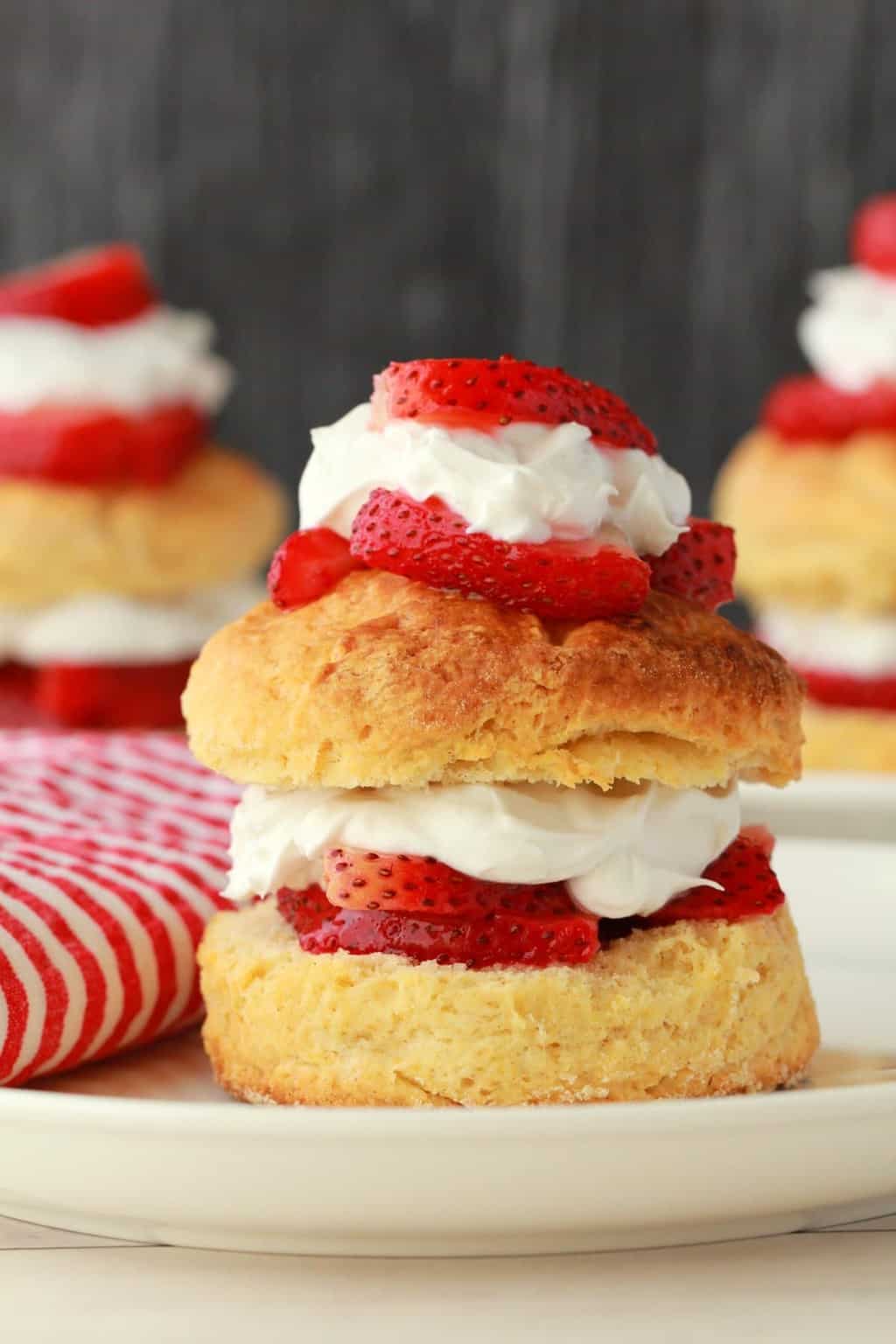 Vegan strawberry shortcake on a white plate with a red and white napkin. 
