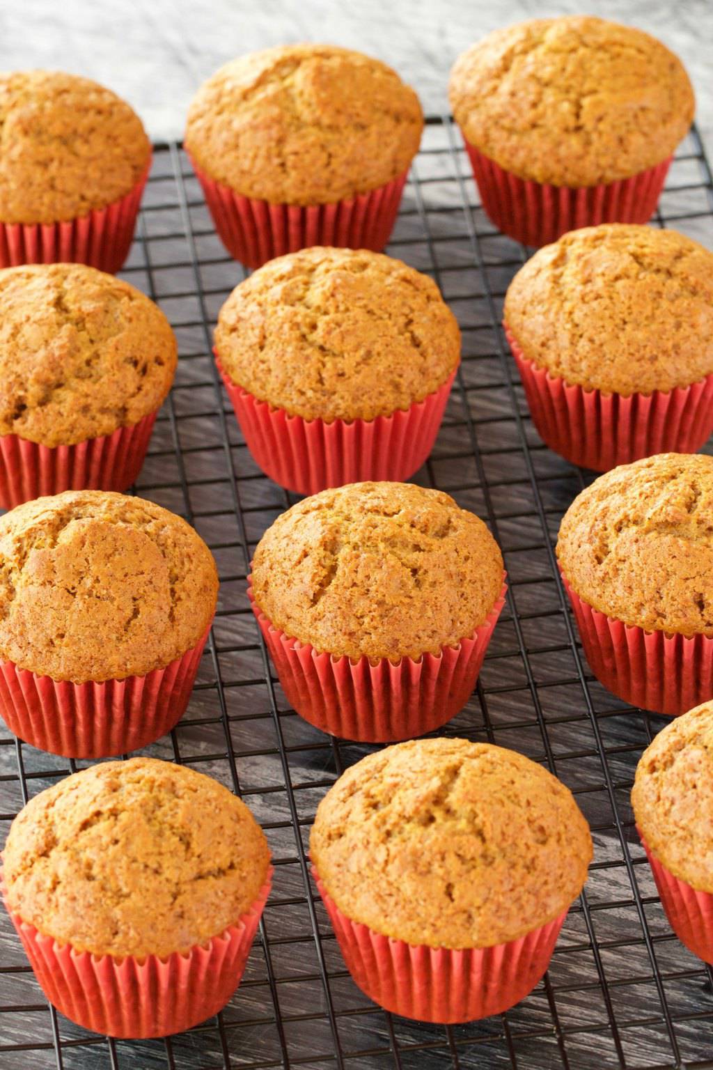 Vegan pumpkin cupcakes cooling on a wire cooling rack. 