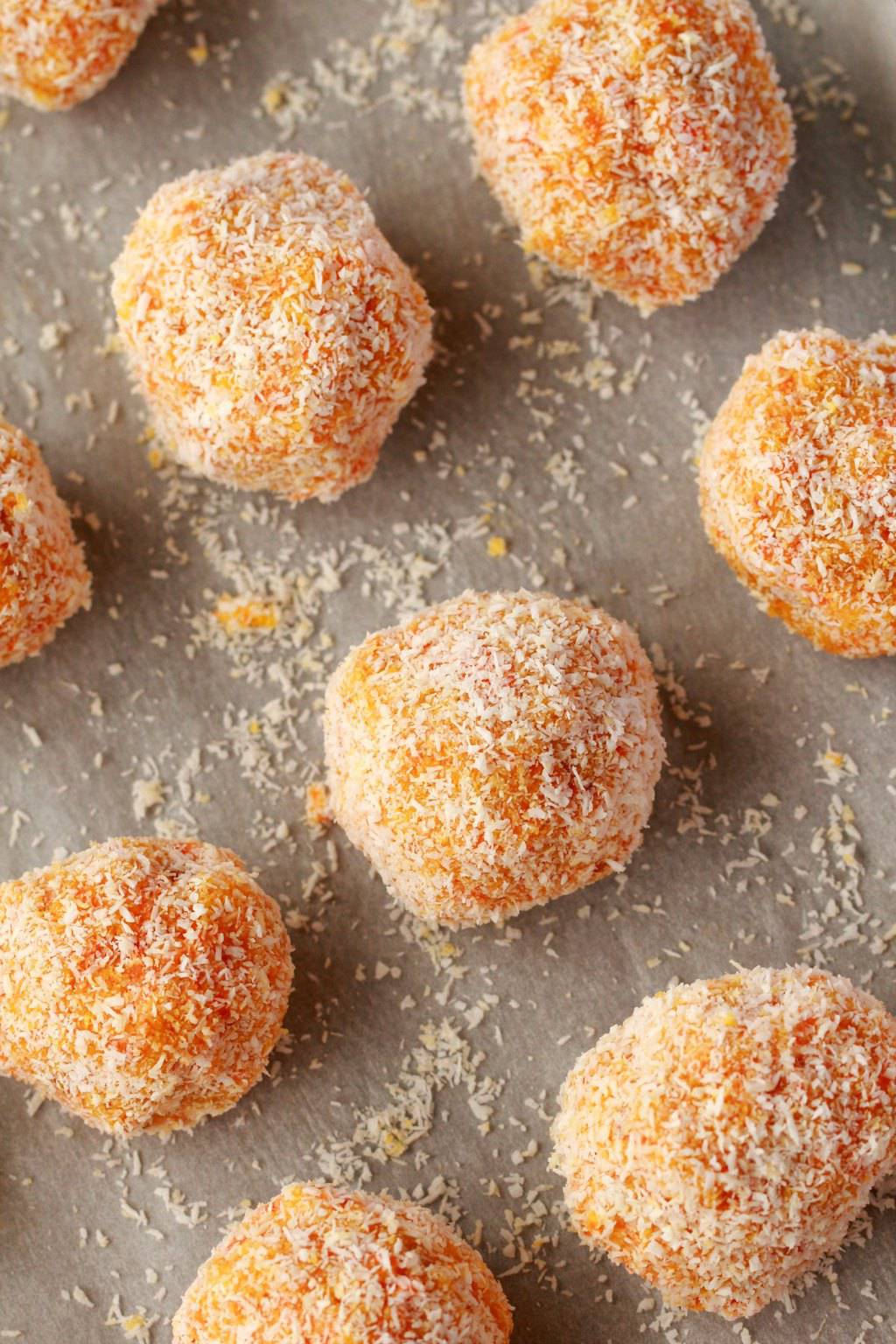 Carrot cake balls on a parchment lined baking tray. 