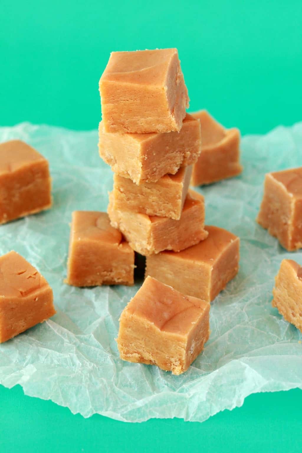 Squares of vegan peanut butter fudge stacked up on top of each other. 