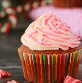 Vegan peppermint cupcake topped with frosting and crushed candy canes.