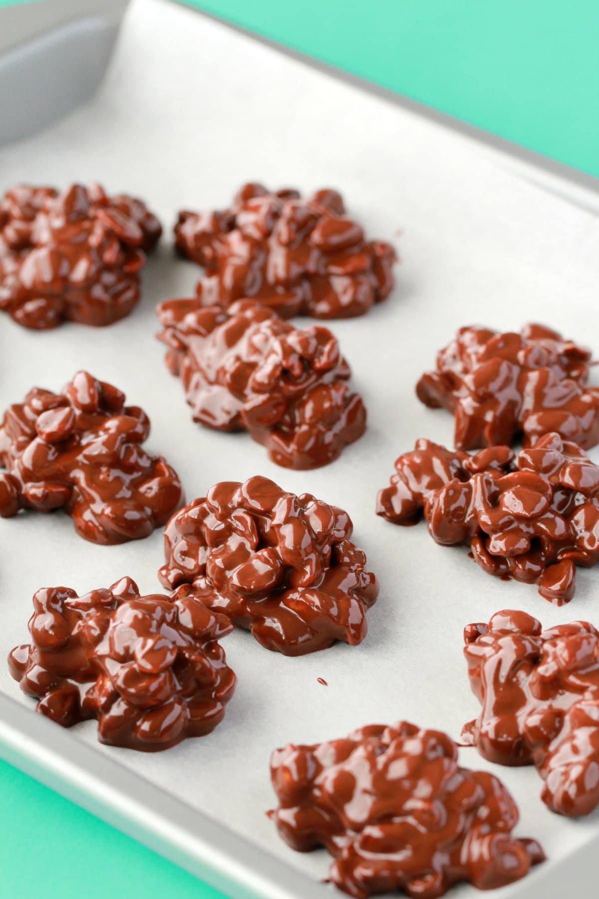 Vegan peanut clusters on a parchment lined baking tray. 