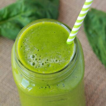 Green smoothie in a glass with a straw