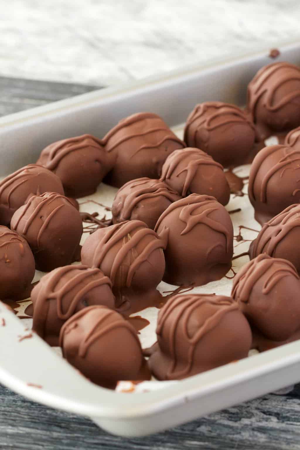 Oreo truffles on a parchment lined tray. 