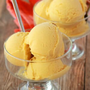 Scoops of vegan mango ice cream in glass bowls.