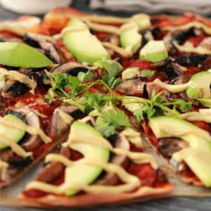 Sliced vegan mushroom pizza with fresh cilantro.