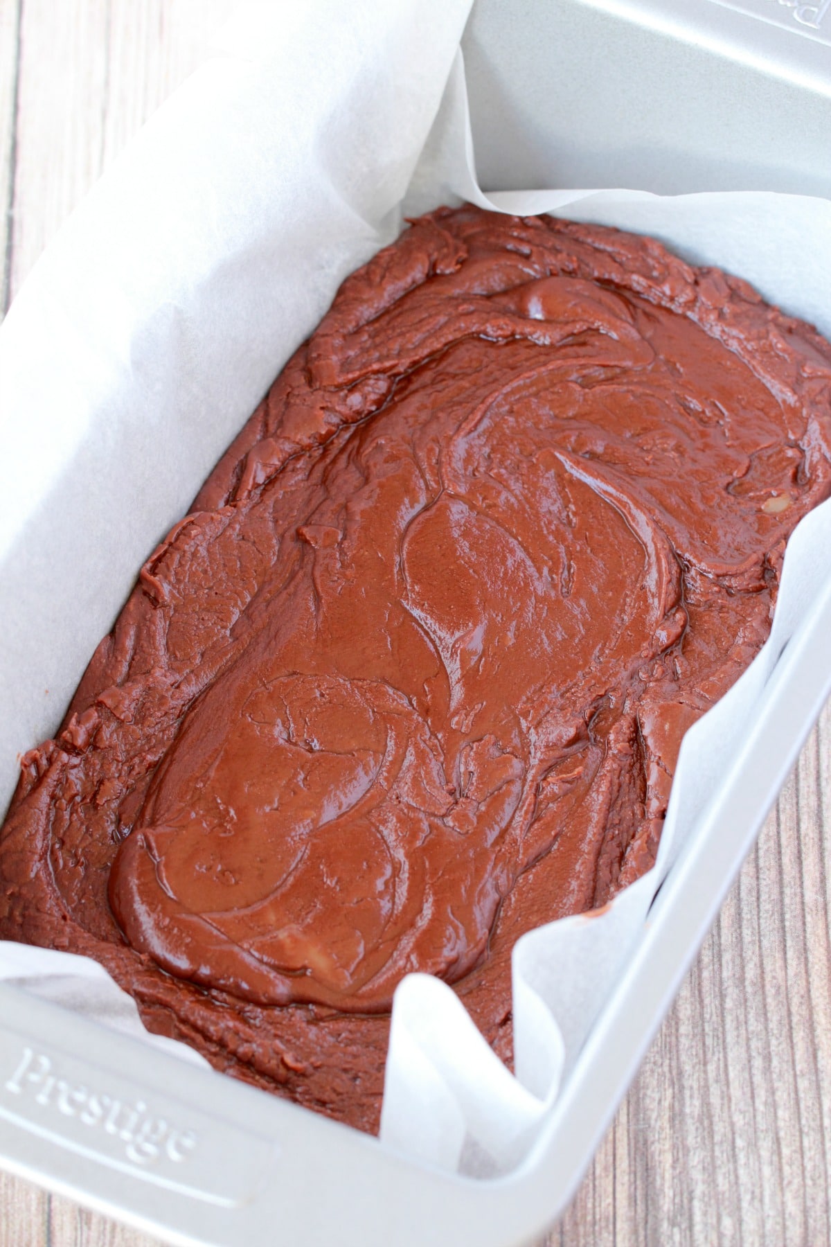 Dairy free fudge mix in a parchment lined loaf pan. 