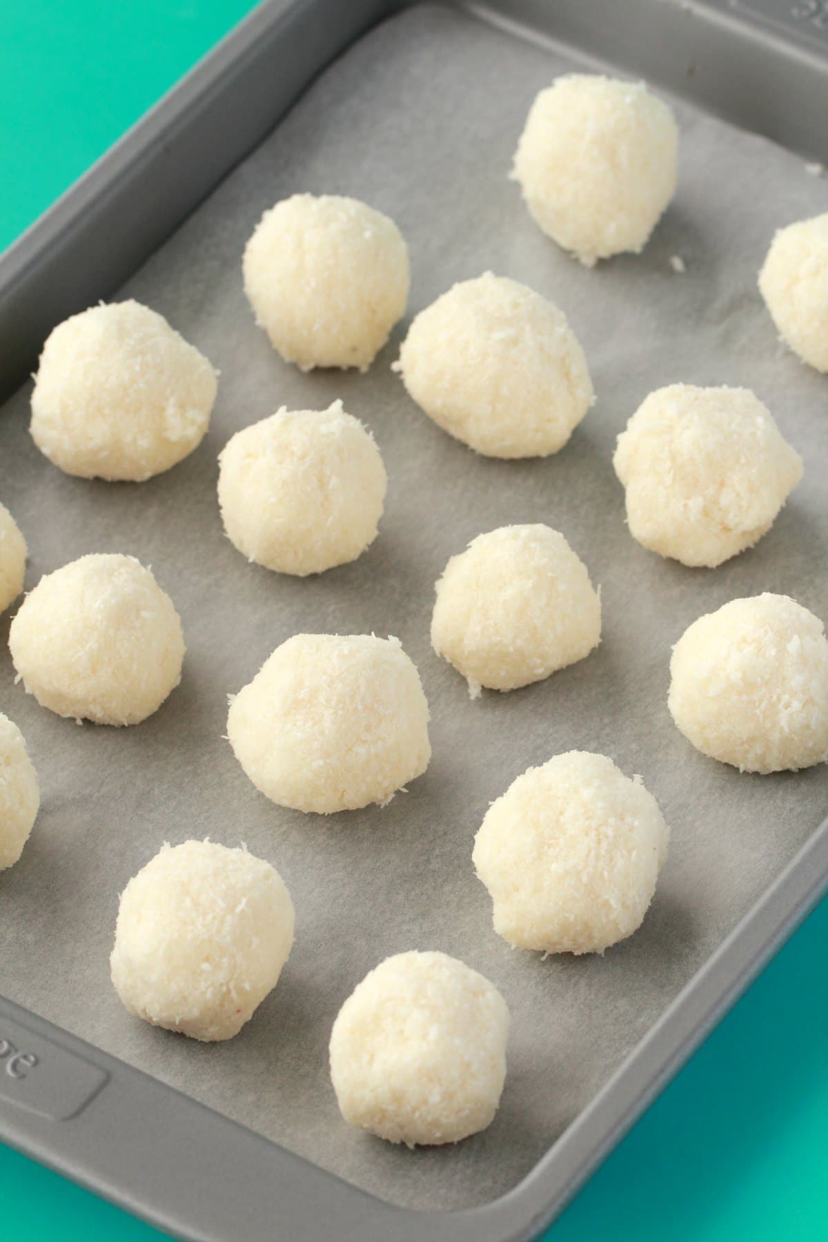 Vegan coconut truffles on a parchment lined baking tray