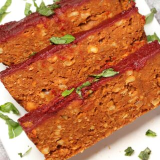Slices of vegan meatloaf on a white plate.