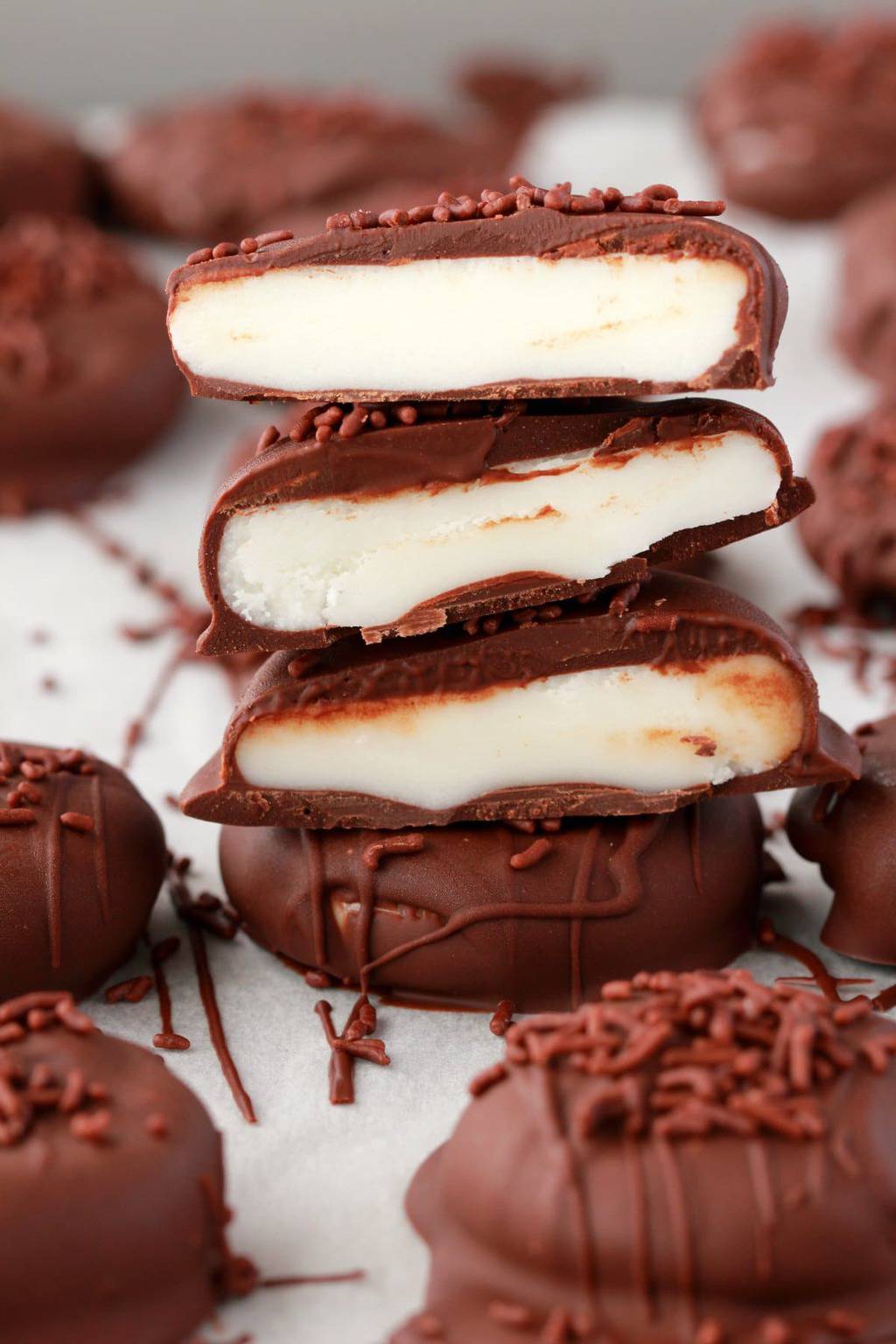 Vegan peppermint patties stacked up and cut in half to show their centers. 