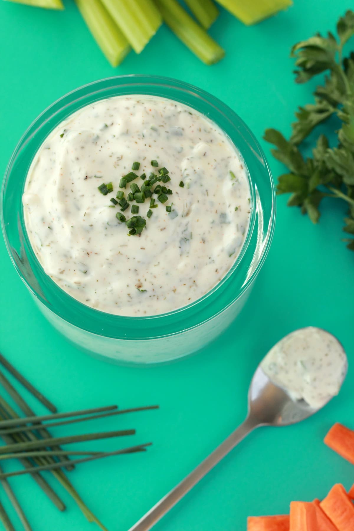Vegan ranch dressing topped with chopped chives in a glass jar. 