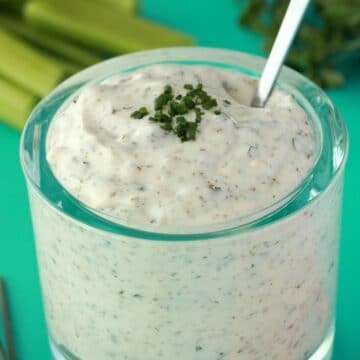 Vegan ranch dressing in a glass jar with a spoon.
