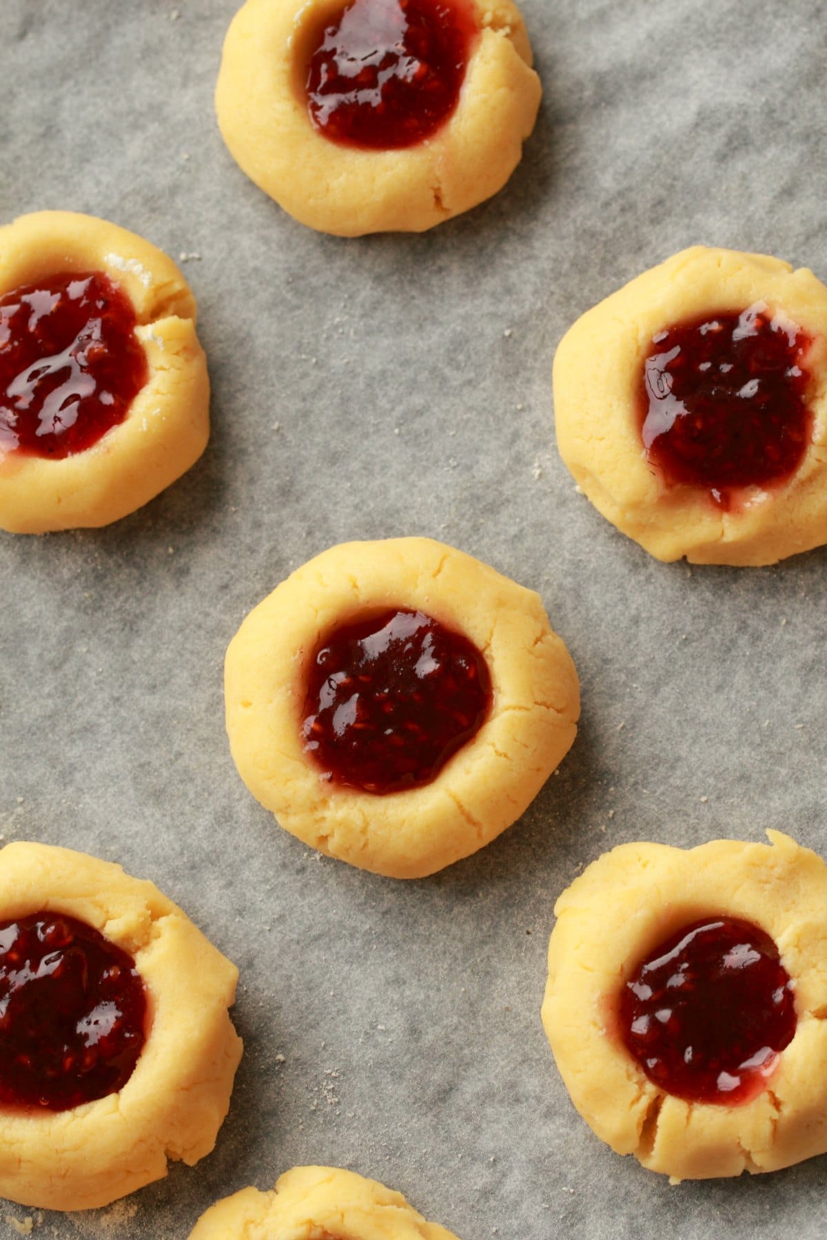 Vegan thumbprint cookies freshly filled with jam and ready to go into the oven. 