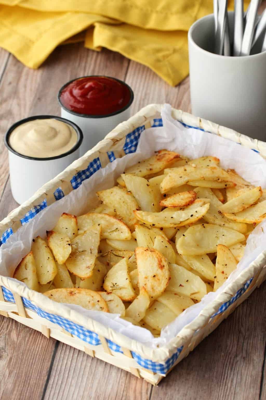 Baked Potato Fries in a basket with cashew sour cream and ketchup next to it. 
