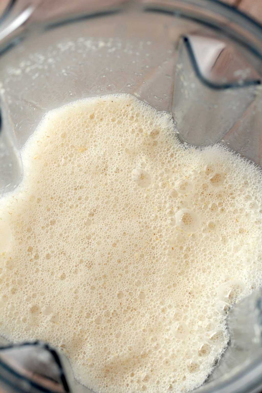 A blender jug full of just blended oat milk. 