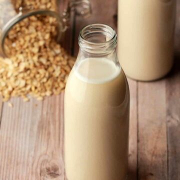 Homemade oat milk in glass milk bottles.