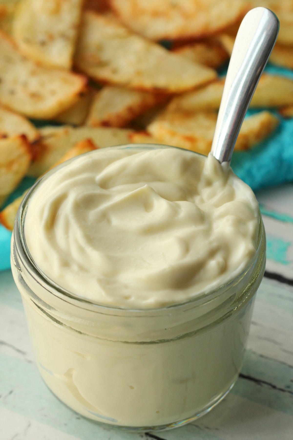 Vegan mayo in a glass jar with a spoon. 