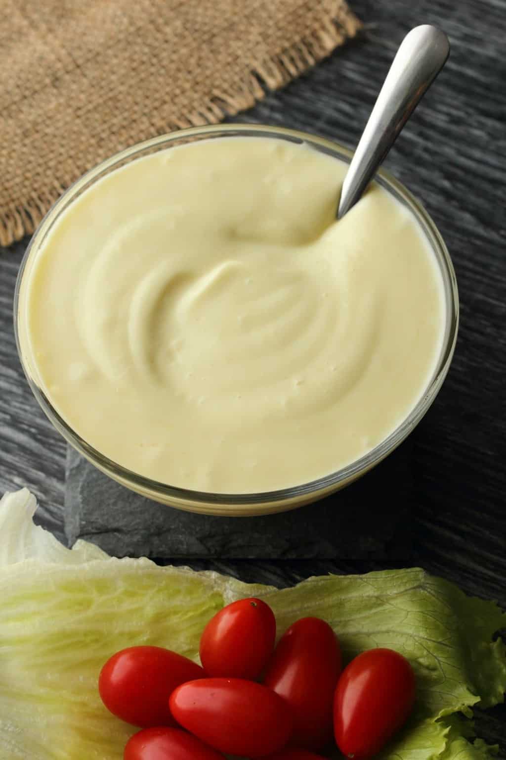 Vegan Mayonnaise in a glass bowl with a spoon. 